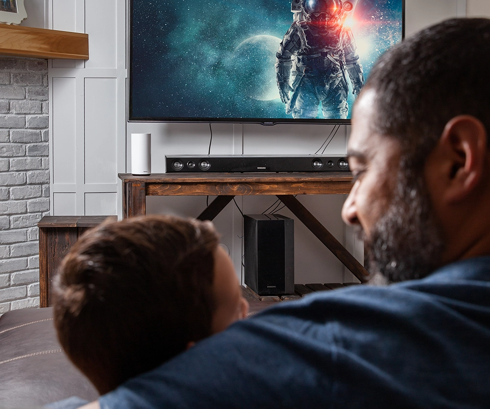 dad with son playing video games, sitting on a couch