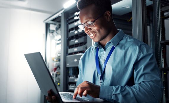 cx-impresa A man using a laptop in a server room