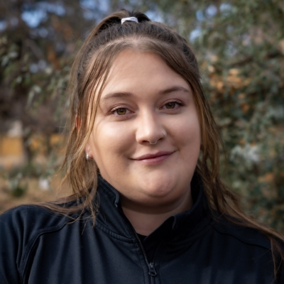 Ananda Wimberger, in a black shirt smiling